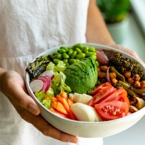 Person holding bowl of vegetables