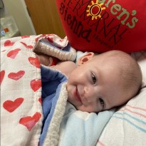 patient sienna laying in hospital bed smiling