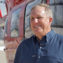Memorial Hermann Life Flight patient, Brian Bremser, stands near a life-saving helicopter.