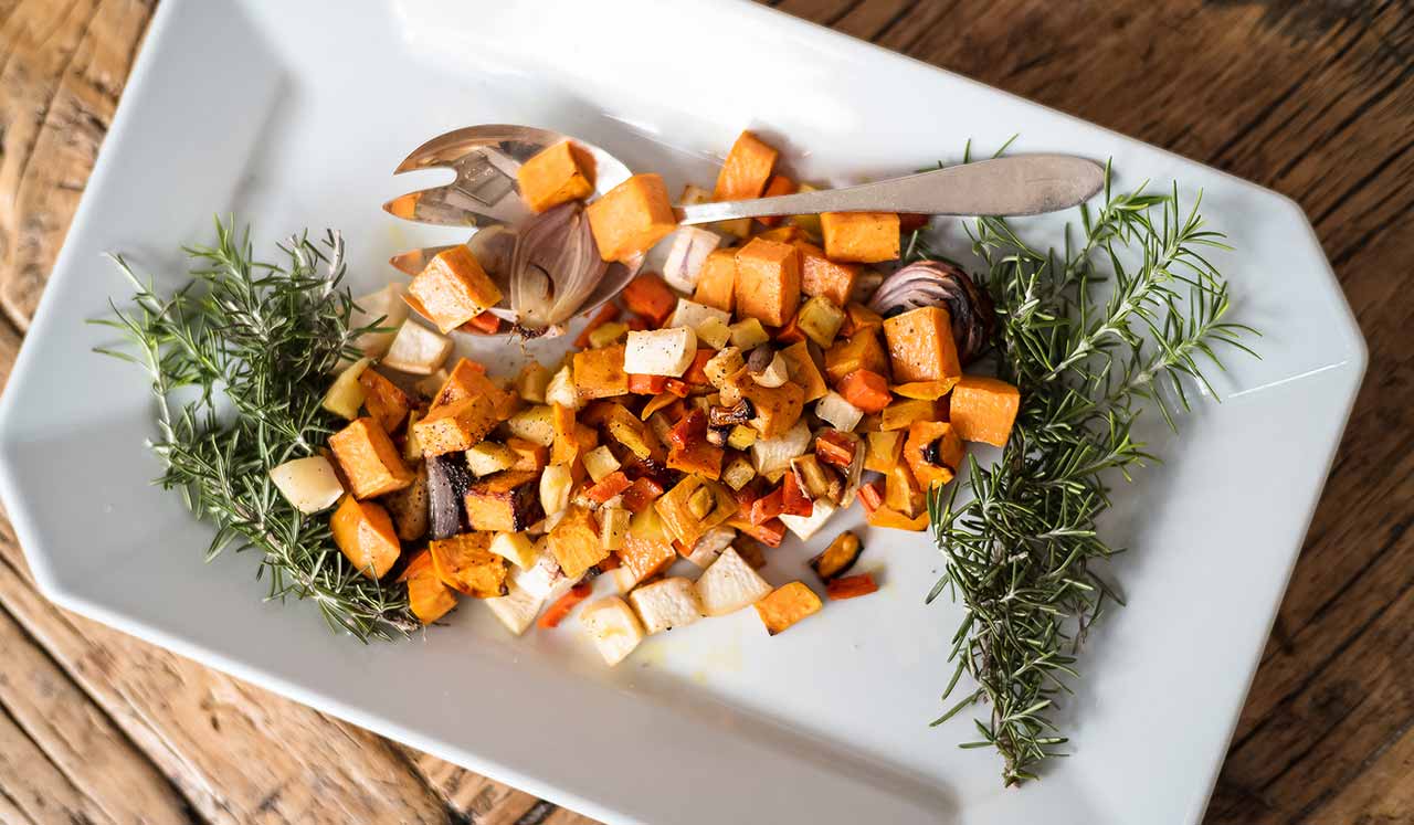 A rectangular plate with an assortment of roasted root vegetables.