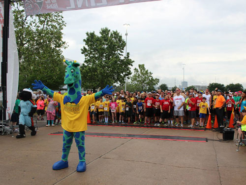 Topper stands in front of racers at Run for the Rose