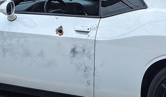 Lavern Smith's car shows impact of bullet hole. 