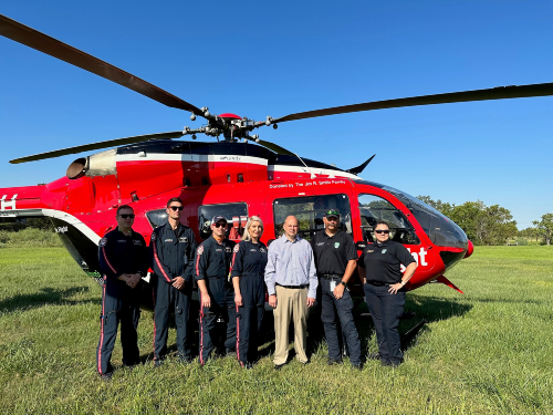 Trauma survivor, Eric Herdejurgen, stands with the Life Flight crew and helicopter.