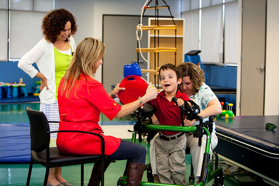 Boy participating in rehabilitation with physician and therapists
