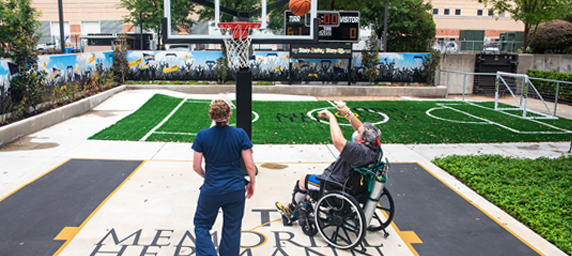 A TIRR Memorial Hermann patient and therapist play basketball as a means of rehabilitation
