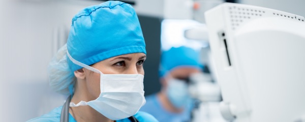 Physician in scrubs, looking at a screen