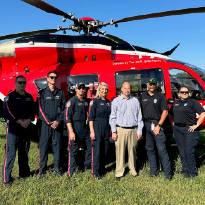 Trauma survivor, Eric Herdejurgen, stands with the Life Flight crew and helicopter.