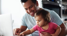 Father using computer with daughter